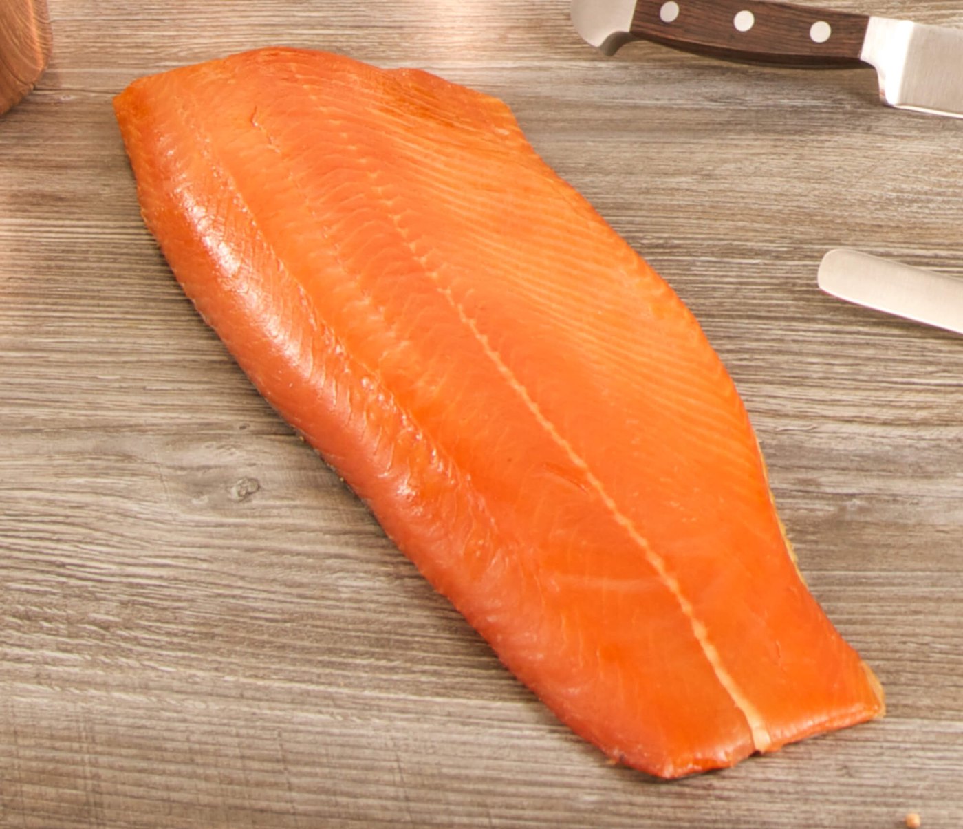 A whole smoked salmon fillet on a wooden board